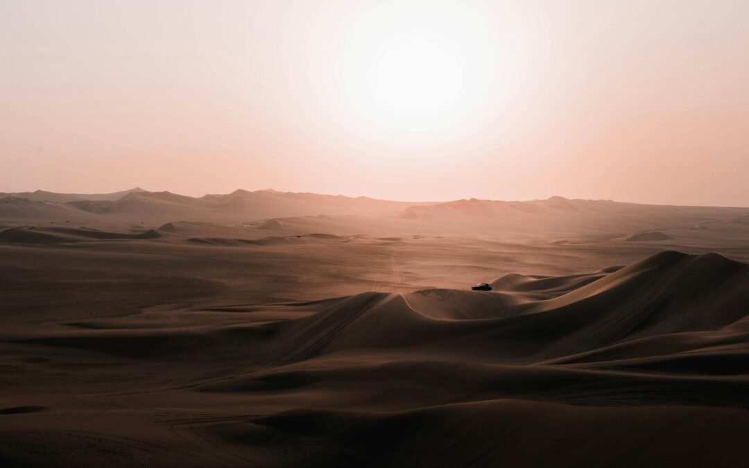 scenery of car riding over desert dunes