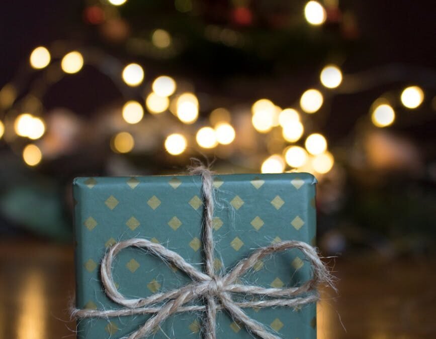close up photo of green gift box on brown wooden surface