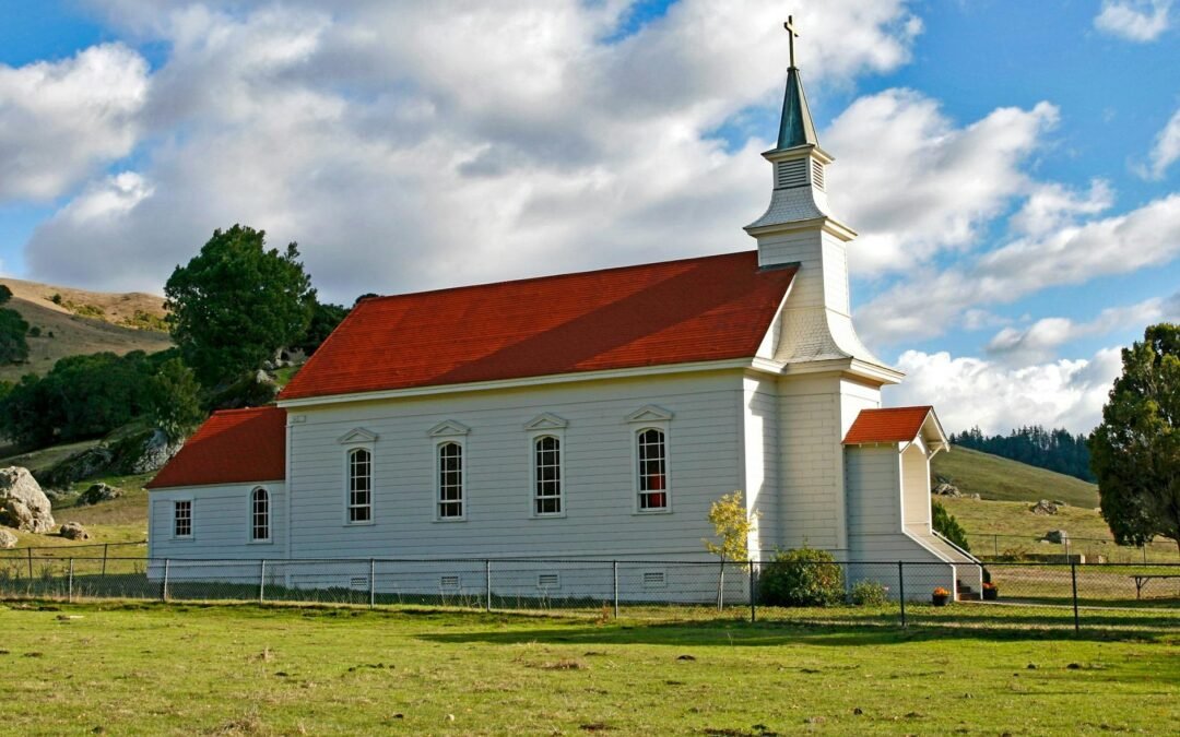 red and white concrete church on green grass field