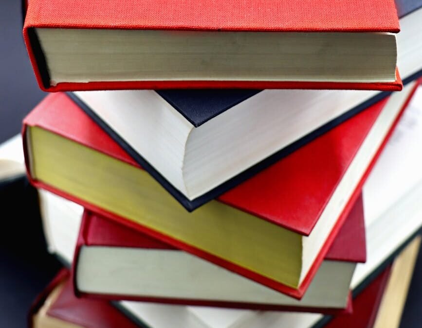 stack of colorful hardcover books on black background