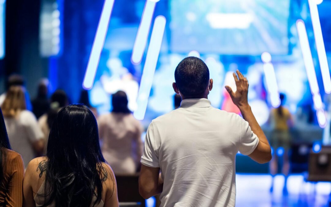man in white t shirt raising his hand