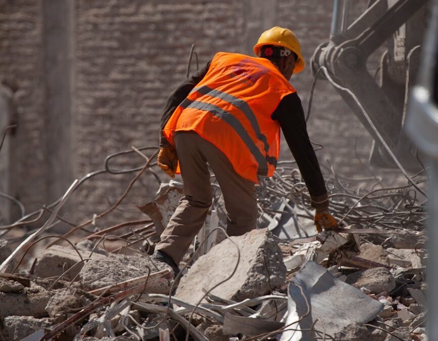 man in reflective vest working in ruins after earthquake