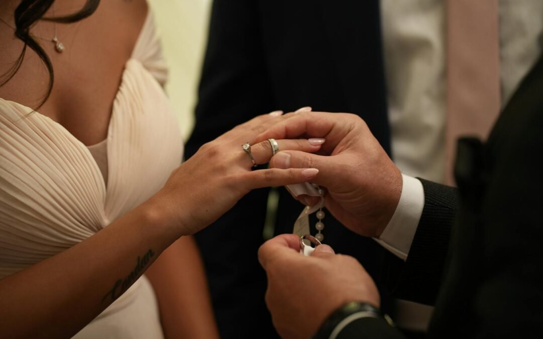 groom putting a wedding ring on bride finger