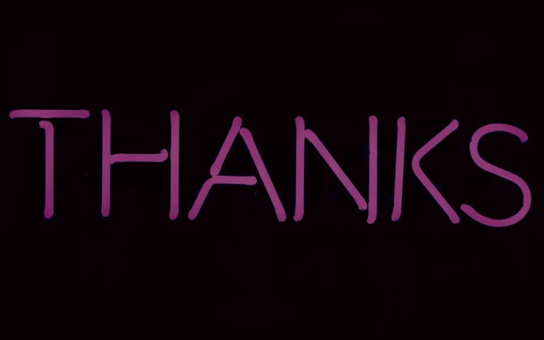 pink neon thanks sign on dark background