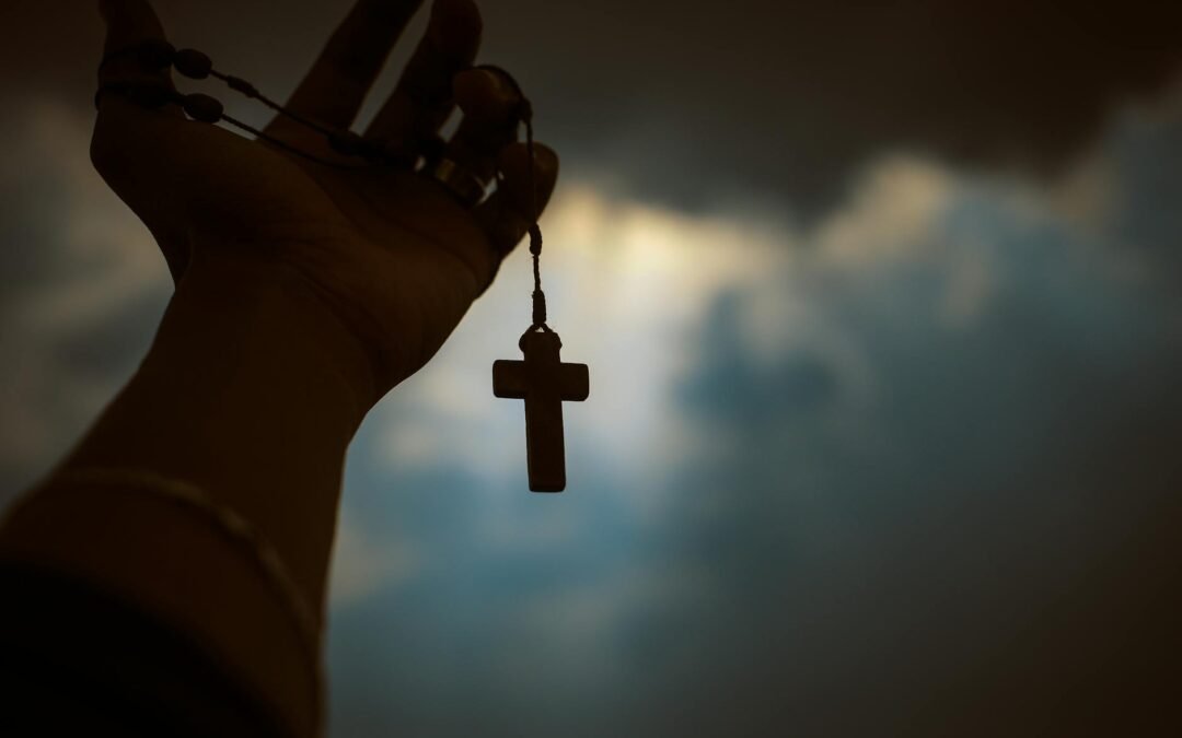 person holding brown wooden cross