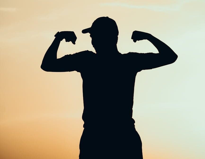 silhouette of man showing off muscles