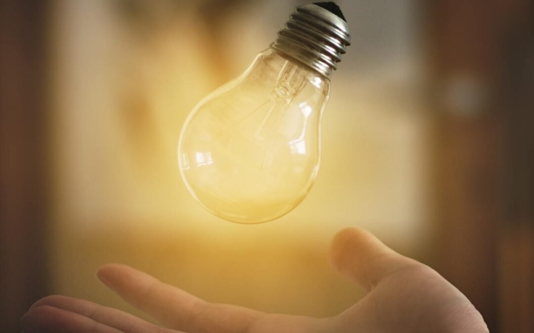 light bulb floating above person s hand