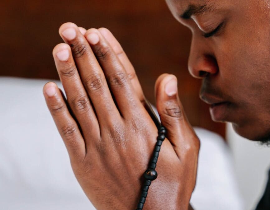 a man praying with a black prayer beads