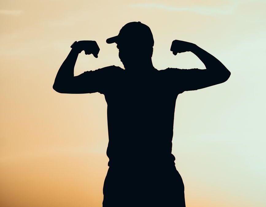 silhouette of man showing off muscles