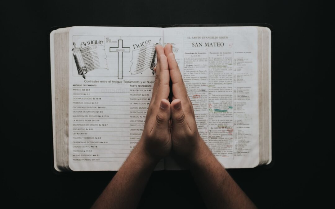 person placing hands on bible