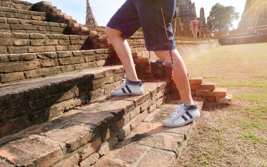 person wearing white and black mid rise sneakers at borobudur indonesia