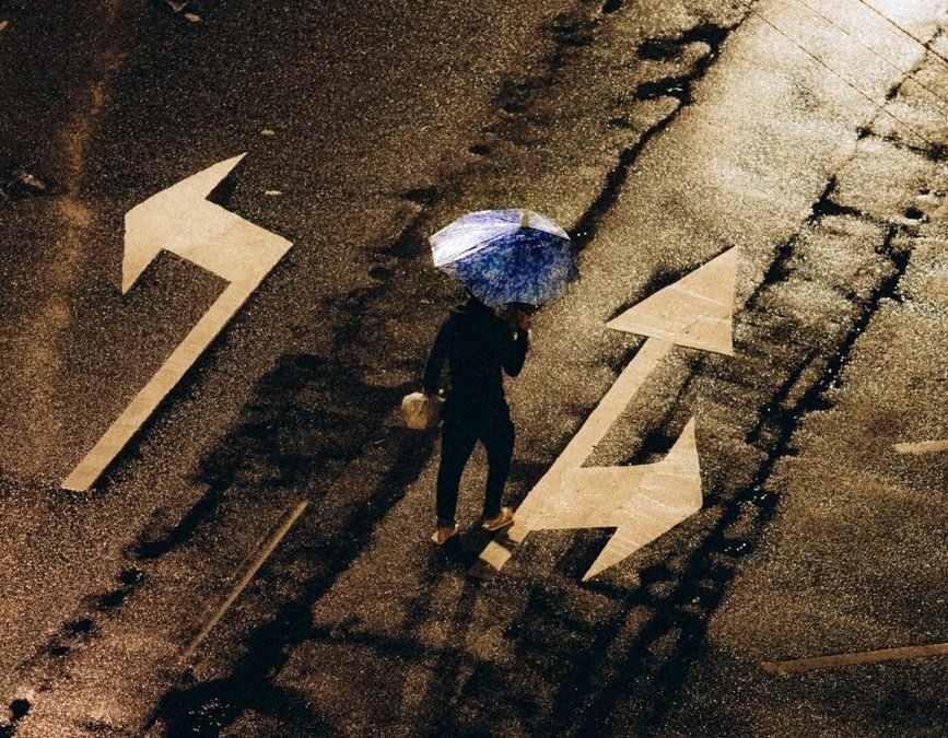 person with umbrella on rainy night street