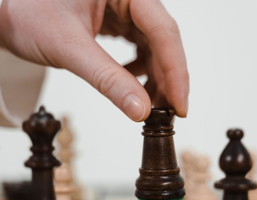 a person holding a chess piece