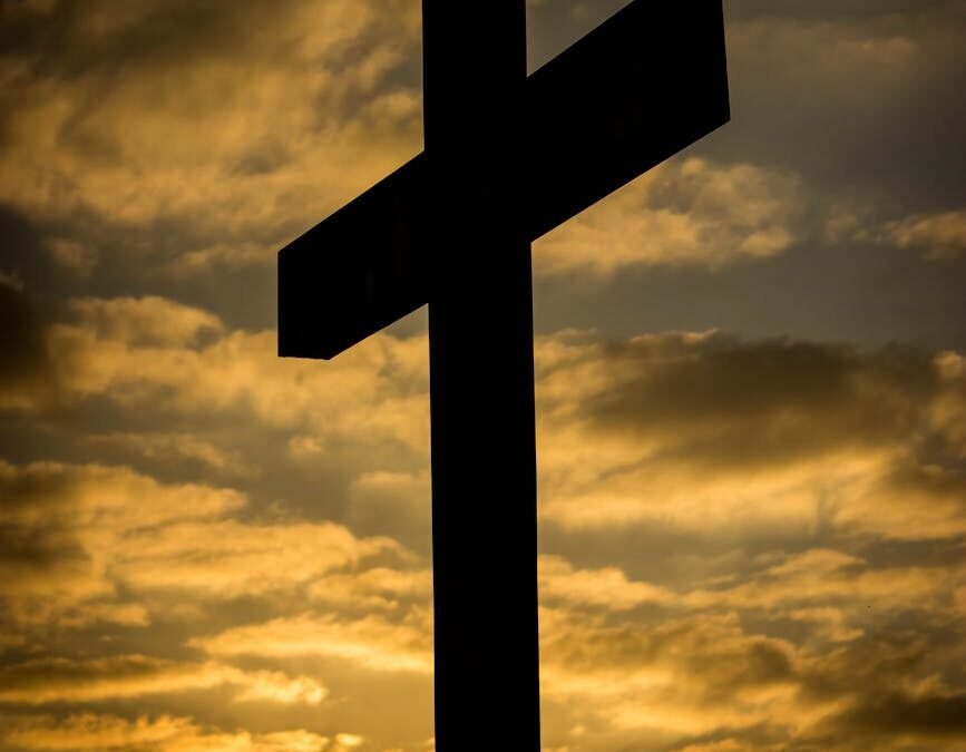 a low angle shot of a silhouette of a cross