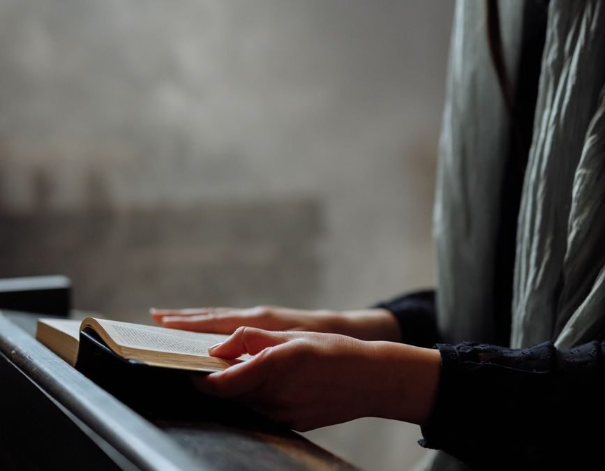 a woman with gray veil holding a bible