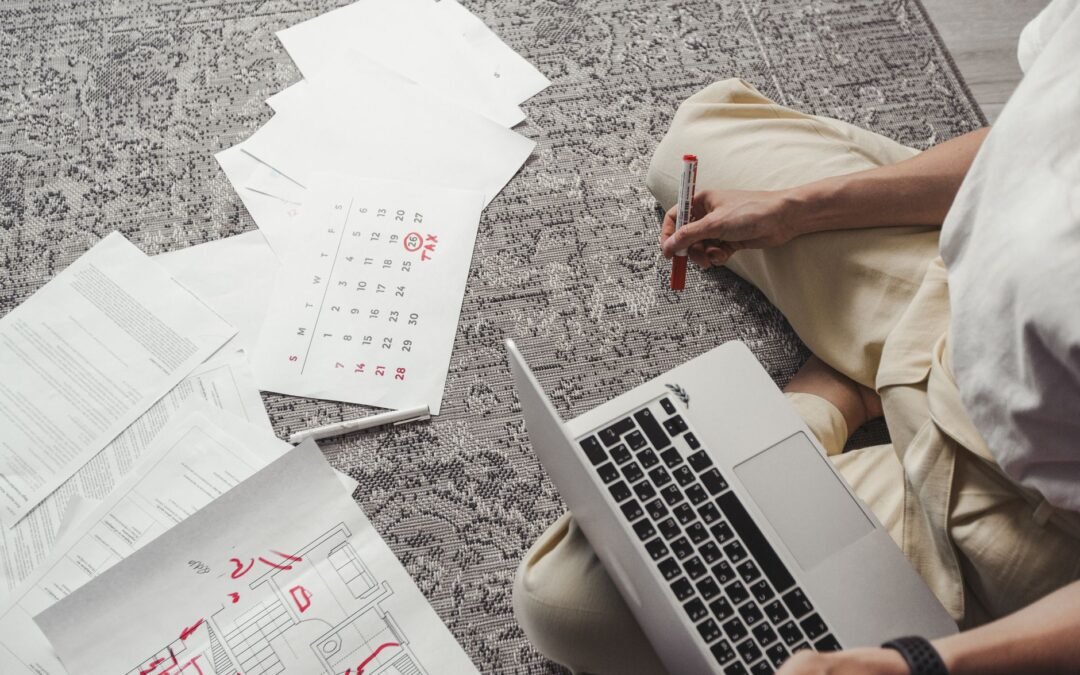 man working on laptop among documents