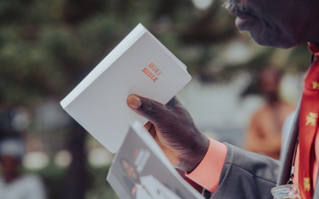 close up of a man holding a holy bible in nigeria