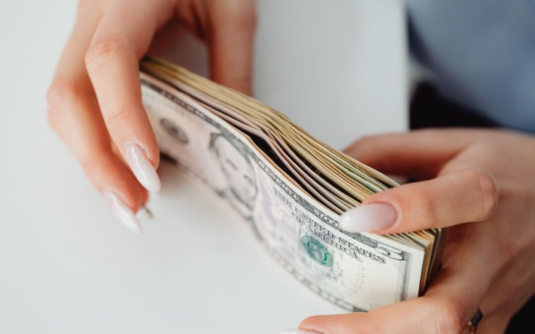 close up shot of a person holding paper money on white surface