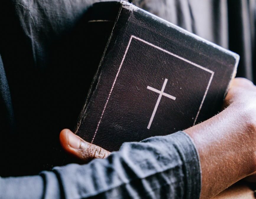 persons hugging a bible