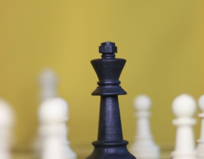 black chess king centered on board with pawns