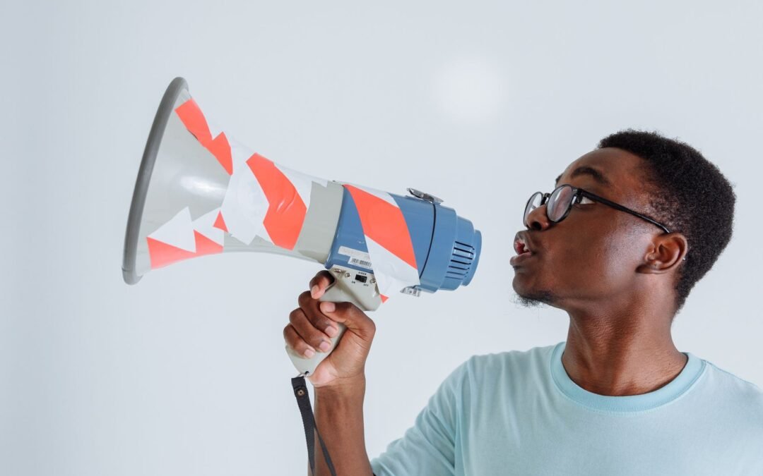 a man in blue shirt holding a megaphone