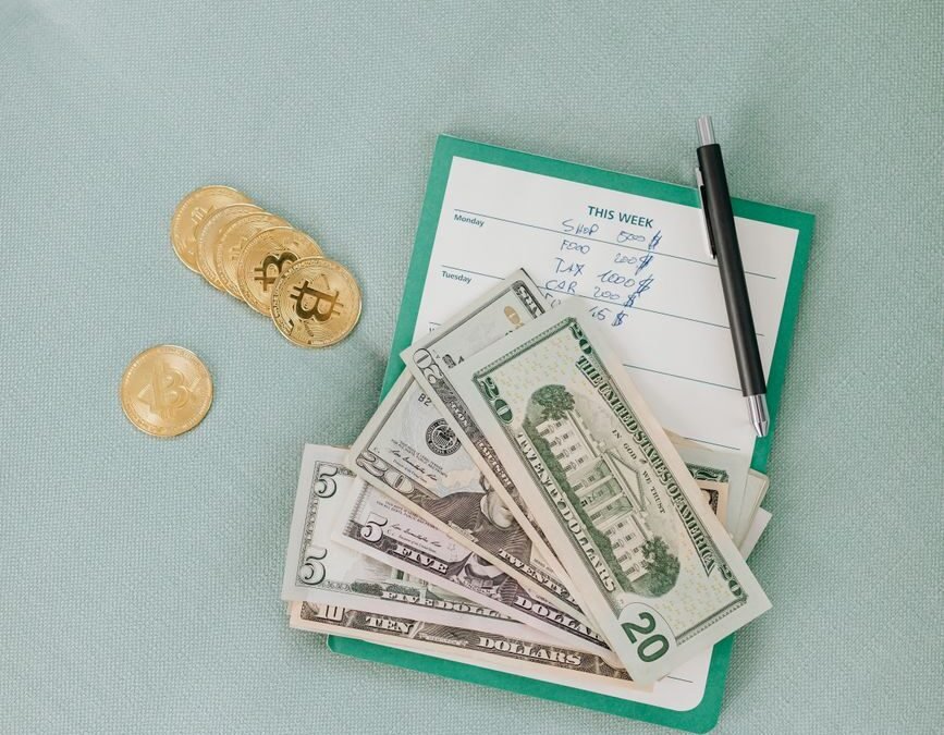 money and bitcoins on green surface